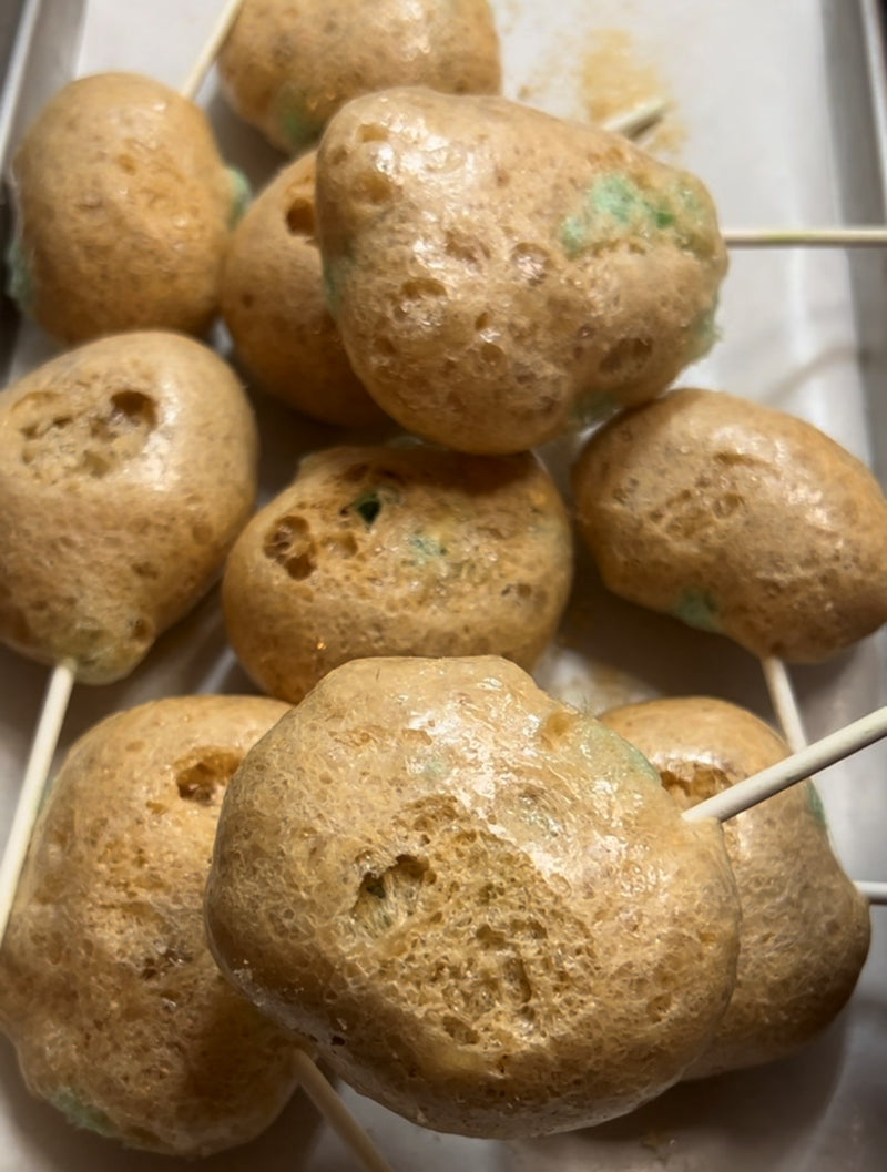 Close-up of airy, crunchy freeze-dried caramel apple suckers on sticks